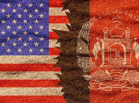 Afghan and American nafghan, ational flags on the sand surface