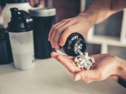 Cropped image of handsome young sportsman preparing sport nutrition in kitchen at home