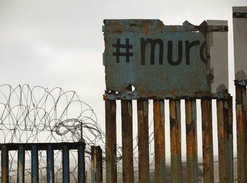 Tijuana, Baja California / Mexico - April 11, 2021: Graffiti spelling out "wall" in Spanish covers a portion of the USA and Mexico border wall.