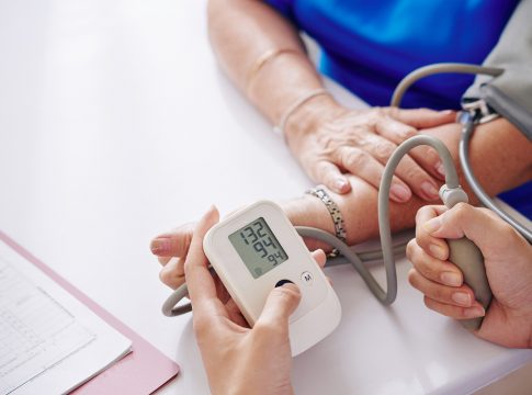 Close-up image of doctor measuring blood pressure of elderly woman during annual check-up
