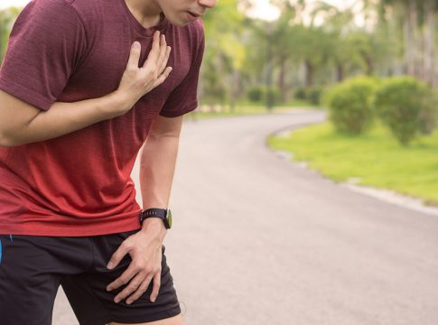 Sport man having heart attack or chest pain after running workout at park. Sport and Health care concept.