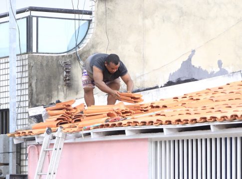 Morador recoloca telhas em sua residência