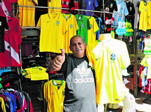 O vendedor Carlos Alberto tem outro motivo para torcer por uma vitória brasileira: o aumento na procura por camisas. Foto: Celso Rodrigues/ Diário do Pará.