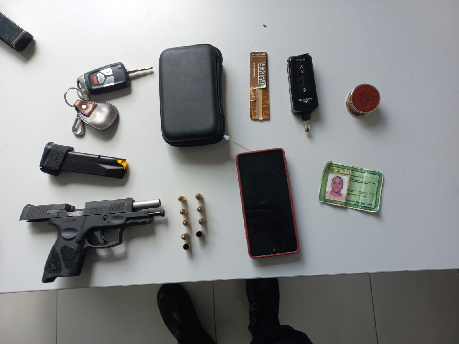 Com o agressor foi encontrada e apreendida uma pistola G3X 9mm com sete munições intactas e duas deflagradas, um pacote contendo 475 gramas de cocaína e um dichavador de maconha. Foto: Divulgação