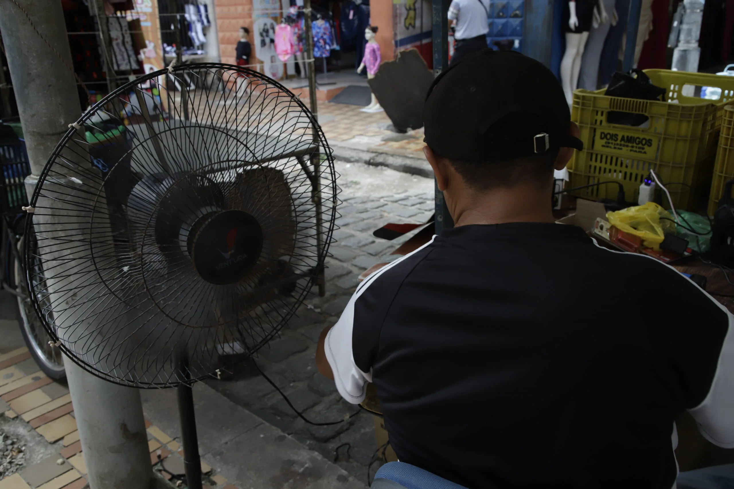 Pessoas usam de várias estratégias para reduzir o calor como o uso de ventiladores e bonés FOTO: Mauro Ângelo