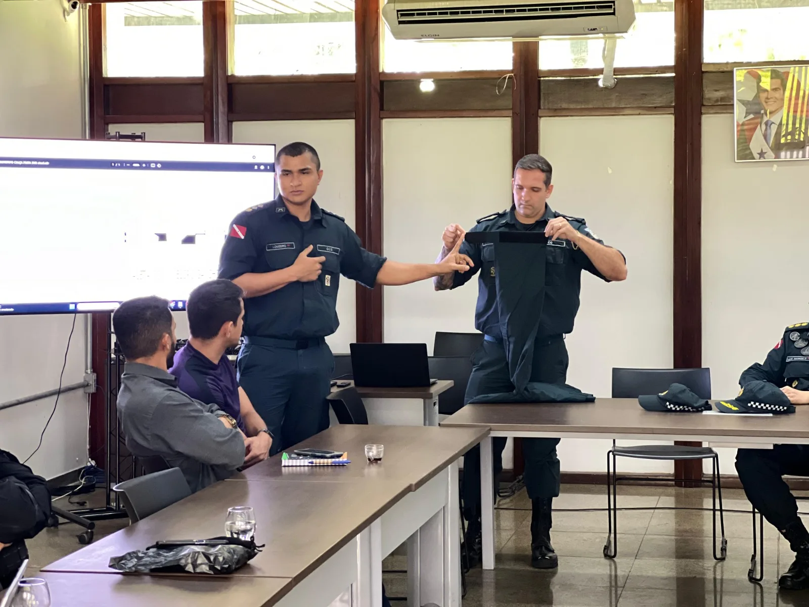 A apresentação iniciou abordando a composição de elementos presentes no fardamento, sendo citada a calça que agora terá a bainha com velcro posta por cima do coturno