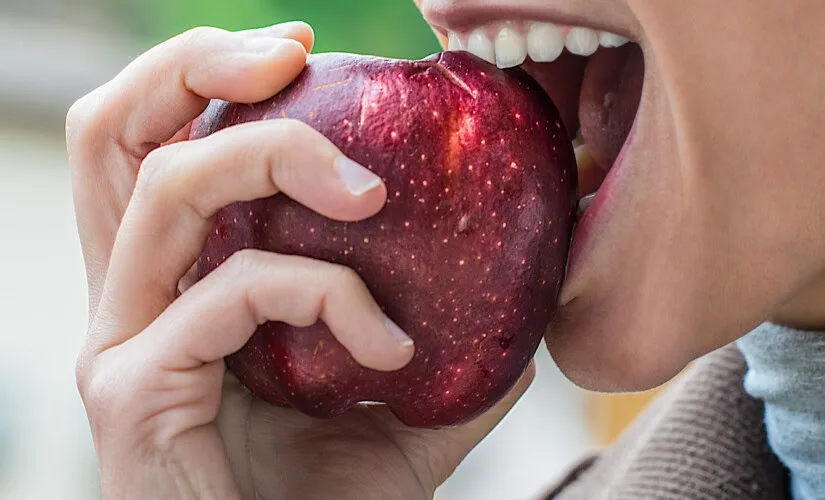 a young attractive girl eats an apple